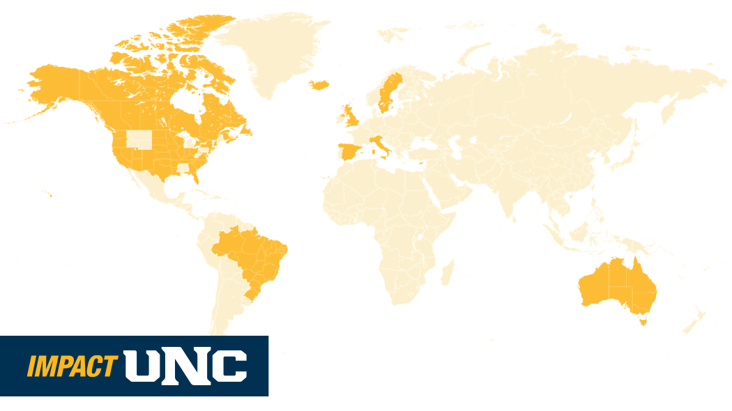 A stylized map of the world, with countries that have contributed to UNC athletics highlighted in gold.