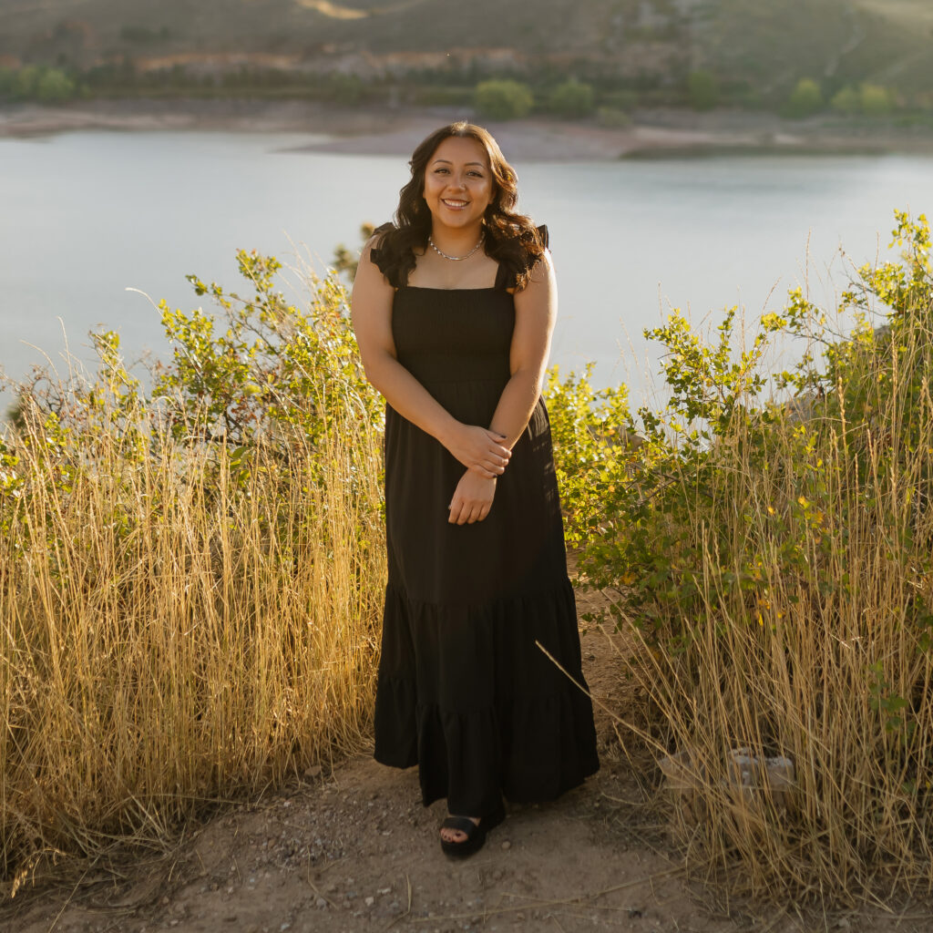 Chanice Sanchez Reves wearing a dress in front of a lake smiling