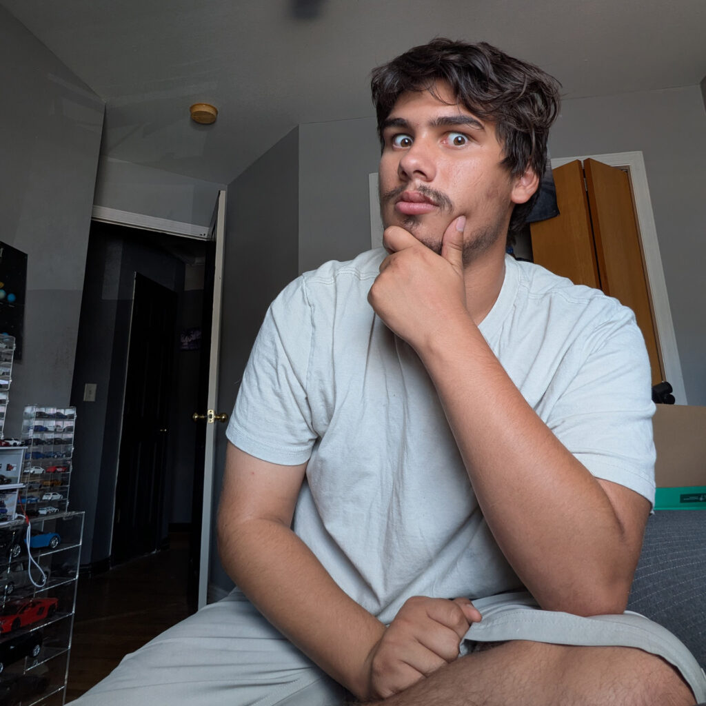 Christopher Clark sitting and facing the camera with his hand on his chin