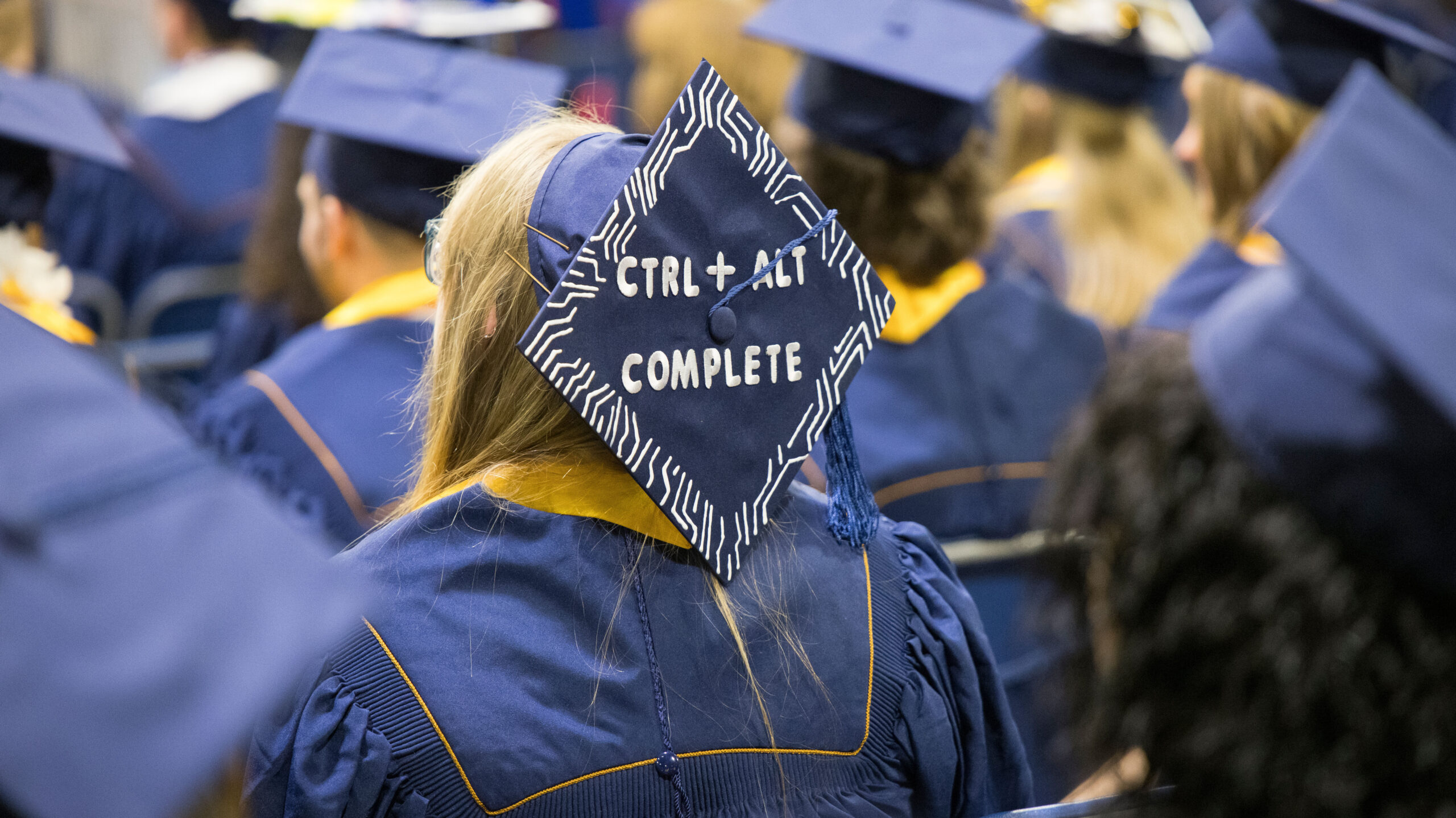 A navy graduation cap that says crtl alt complete