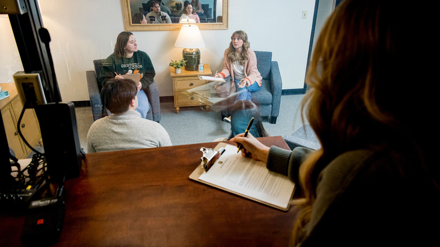Clinician observing a counseling session from observation room.