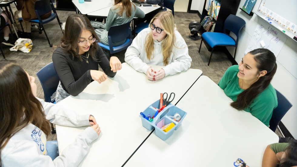 A group of female students are working together at a table