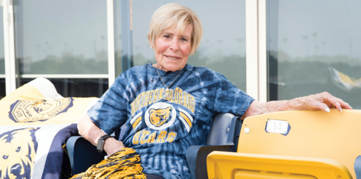 UNC alum Edye Nottingham sitting at Nottingham Field in UNC Blue and Gold.