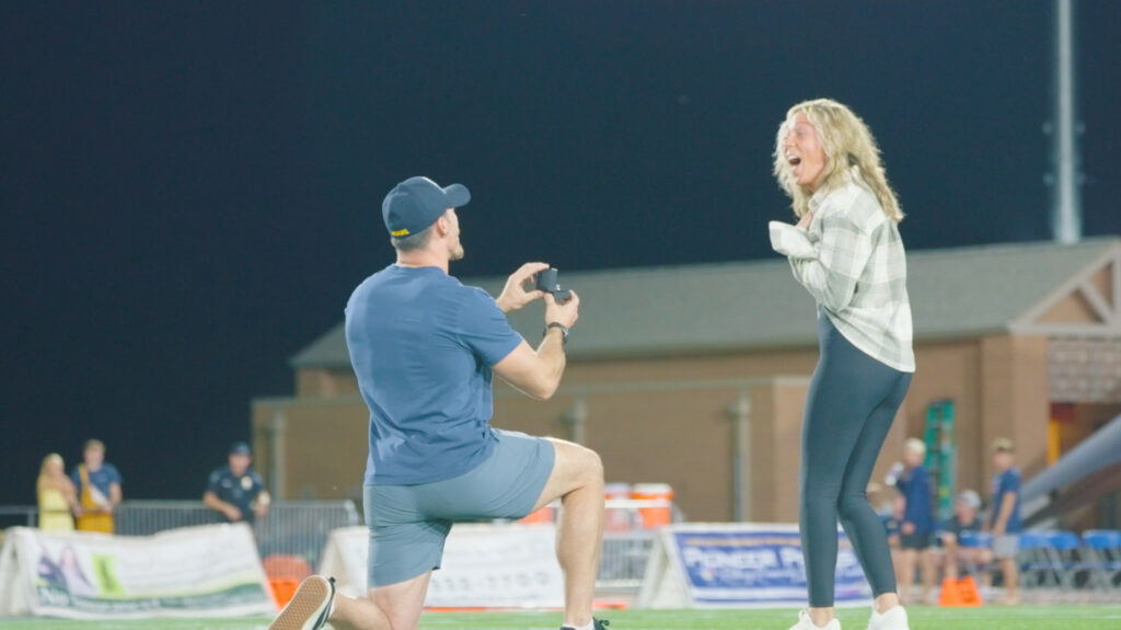 A man on one knee proposing to a woman on Nottingham Field