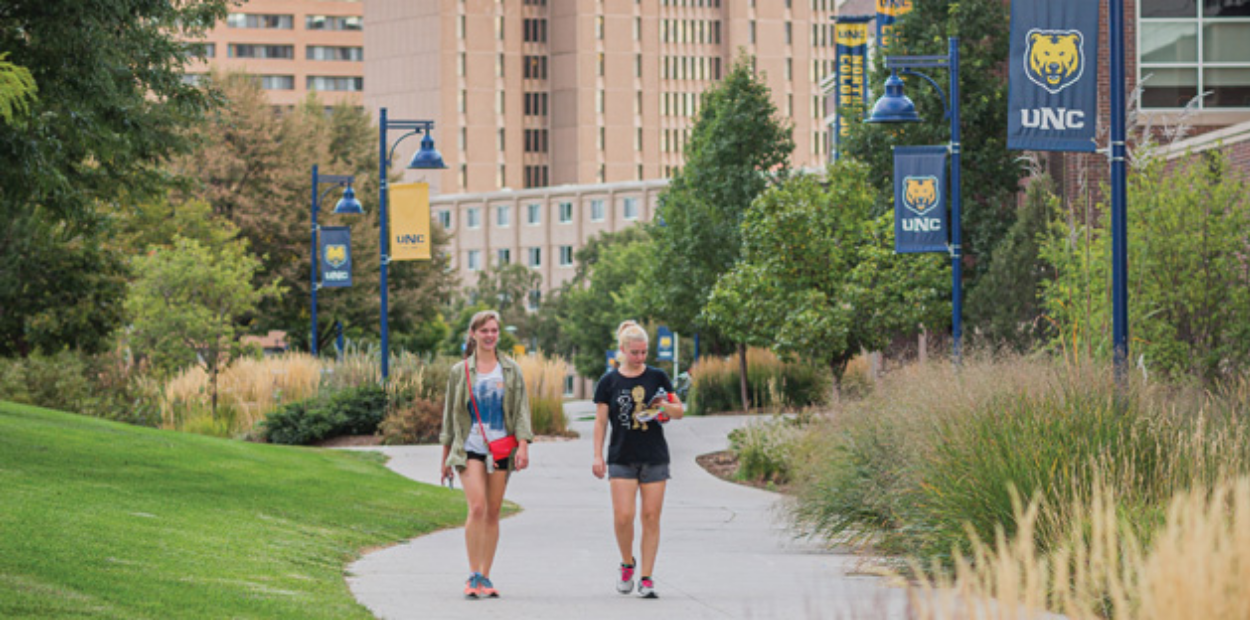 A pair of female students walking through UNC's campus together.