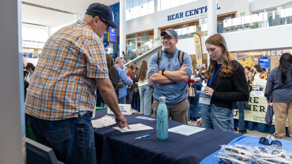a high school student and her dad listening to someone at the info fair at the Future Teacher Conference 2026