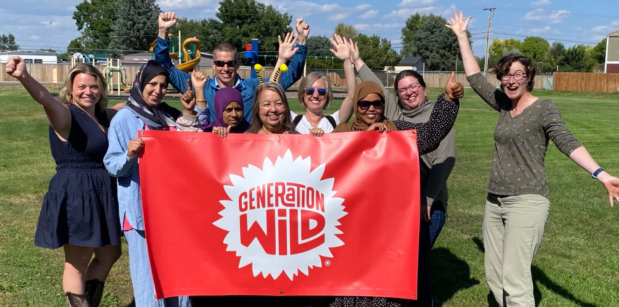 A group of adults holding up their hands and a red flag that says Generation Wild