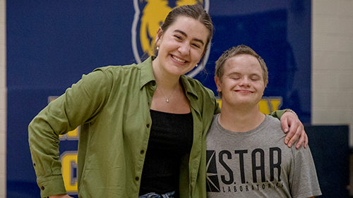 Two students are smiling together looking directly at the camera while attending the end of year celebration for the goal program.
