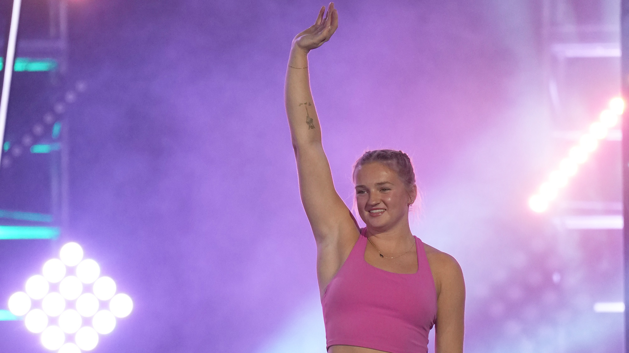 Taylor Greene is holding her hand up and smiling