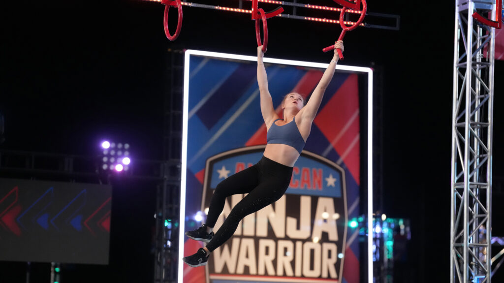 Taylor Greene competing on American Ninja Warrior, swinging from hoops