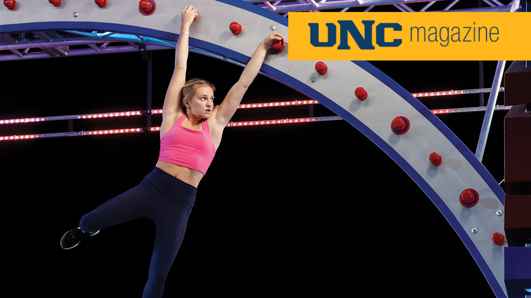 UNC student Taylor Greene swinging from an obstacle on an American Ninja Warrior course.