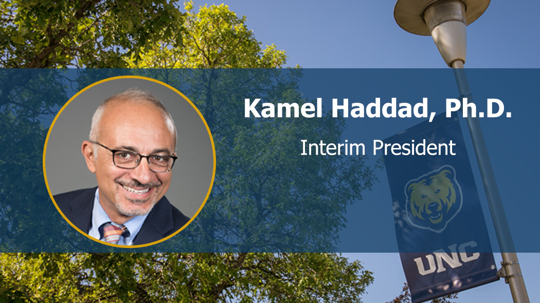 Portrait of Kamel Haddad facing forward and smiling on UNC branded background.
