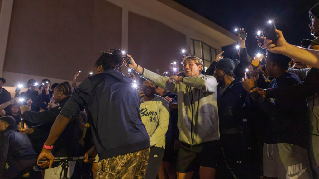 UNC students cheering in a group with their phones lights on