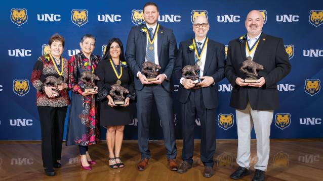 Six honored alumni holding their trophies