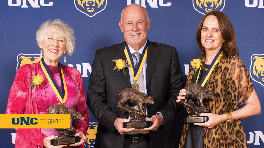 The three awardees for UNC's 2026 Honored Alumni standing together and holding their awards.