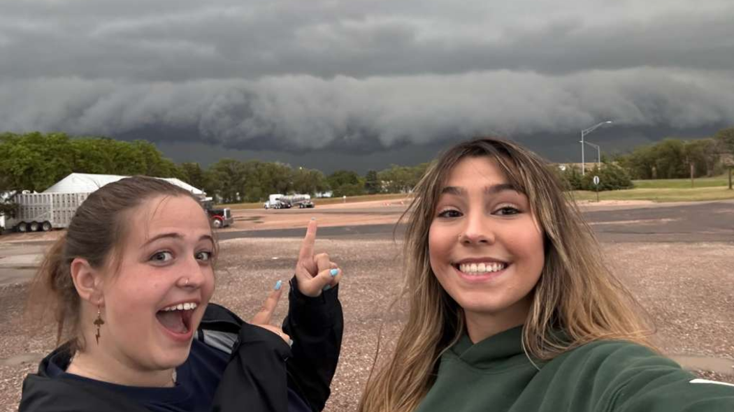 UNC senior Janae Acheson excitedly pointing to a storm cloud with another student.
