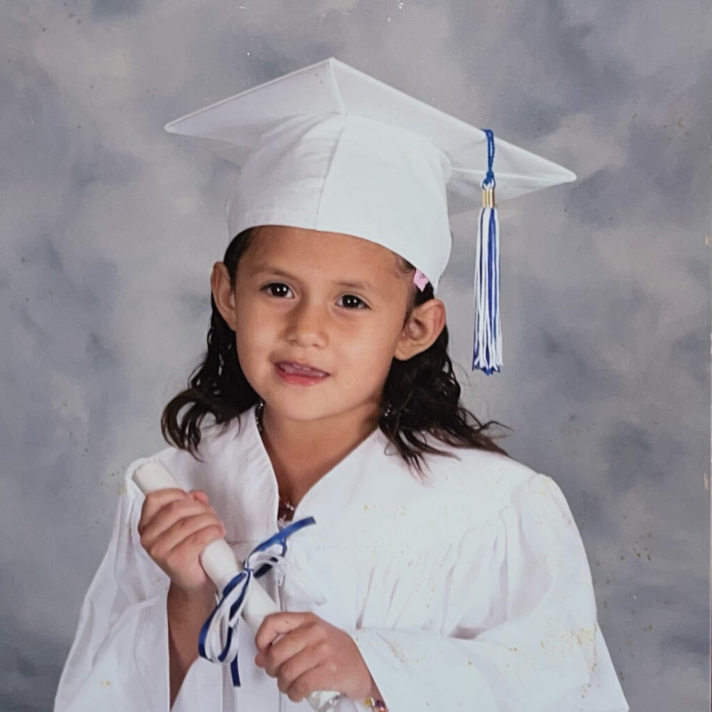 Jasmin Mazariegos Rodriguez as a young child in a graduation outfit