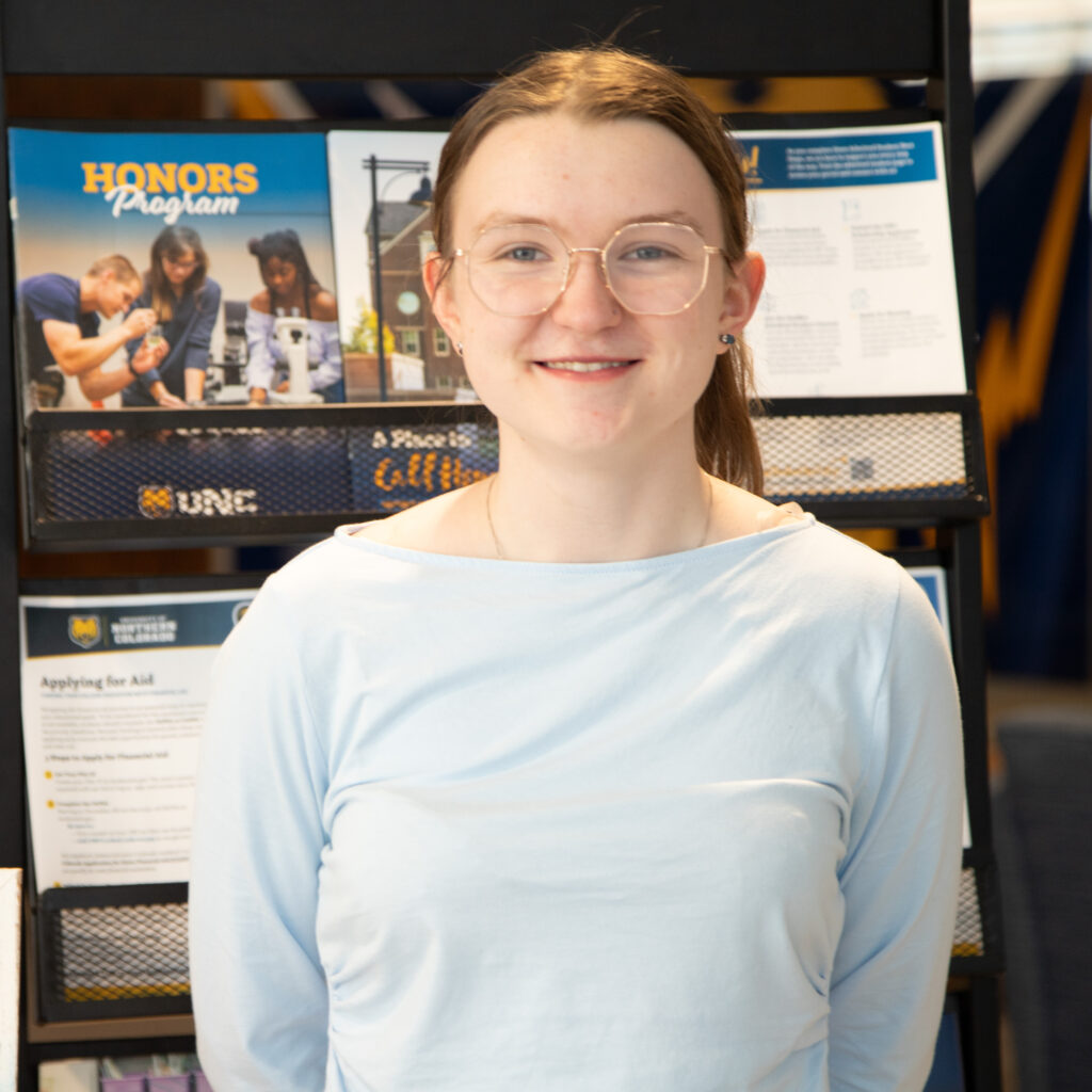 Jasmine Gaines looking at the camera and smiling while wearing glasses