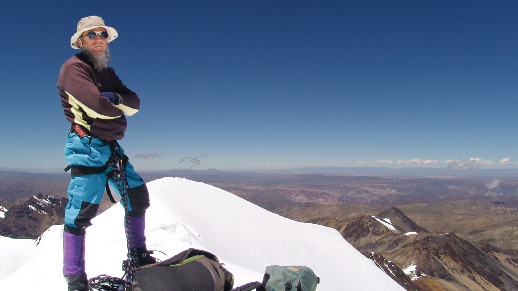 UNC alum John Brett standing on top of a snowy mountain.