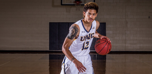 Jonah Radebaugh dripping a basketball wearing his UNC uniform