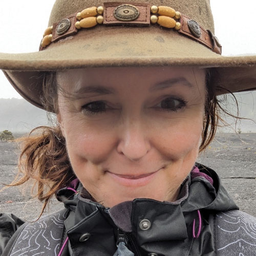 Karen Barton wearing a brown hat smiling at the camera