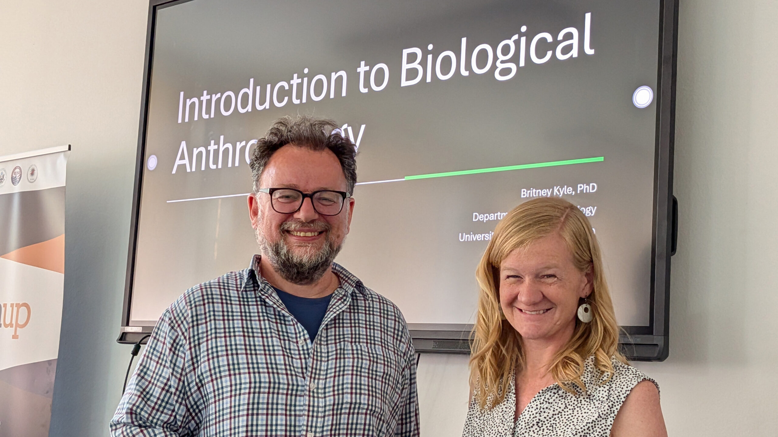 Arsim Canolli and Britney Kyle are standing next to each other in a classroom