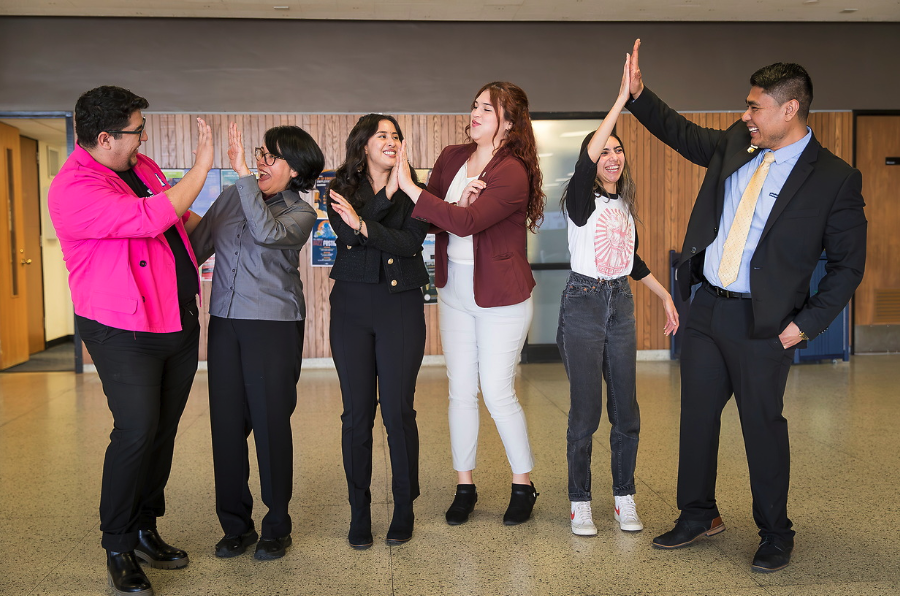 UNC staff members high-five each other during a celebratory moment at the 2025 Latina Youth Leadership Conference.
