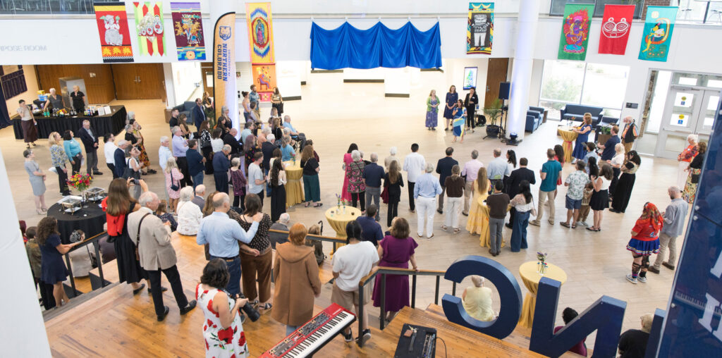 A group of people looking at a blue banner on the wall
