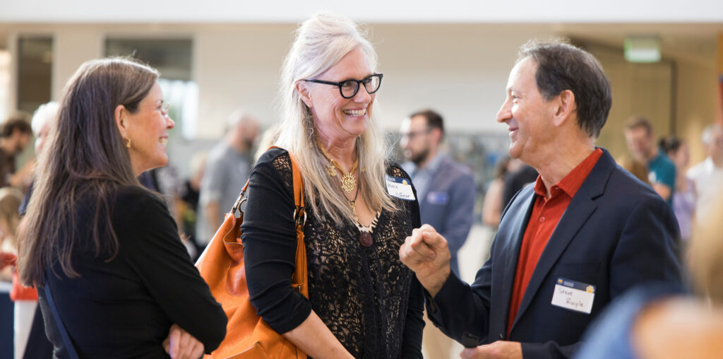 Three people talking and smiling