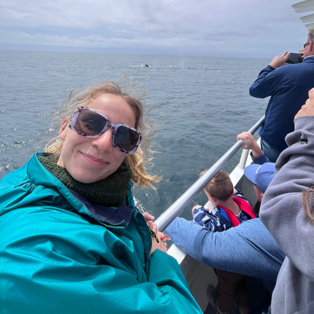 Madison Tucker wearing sunglasses and smiling at the camera on a boat