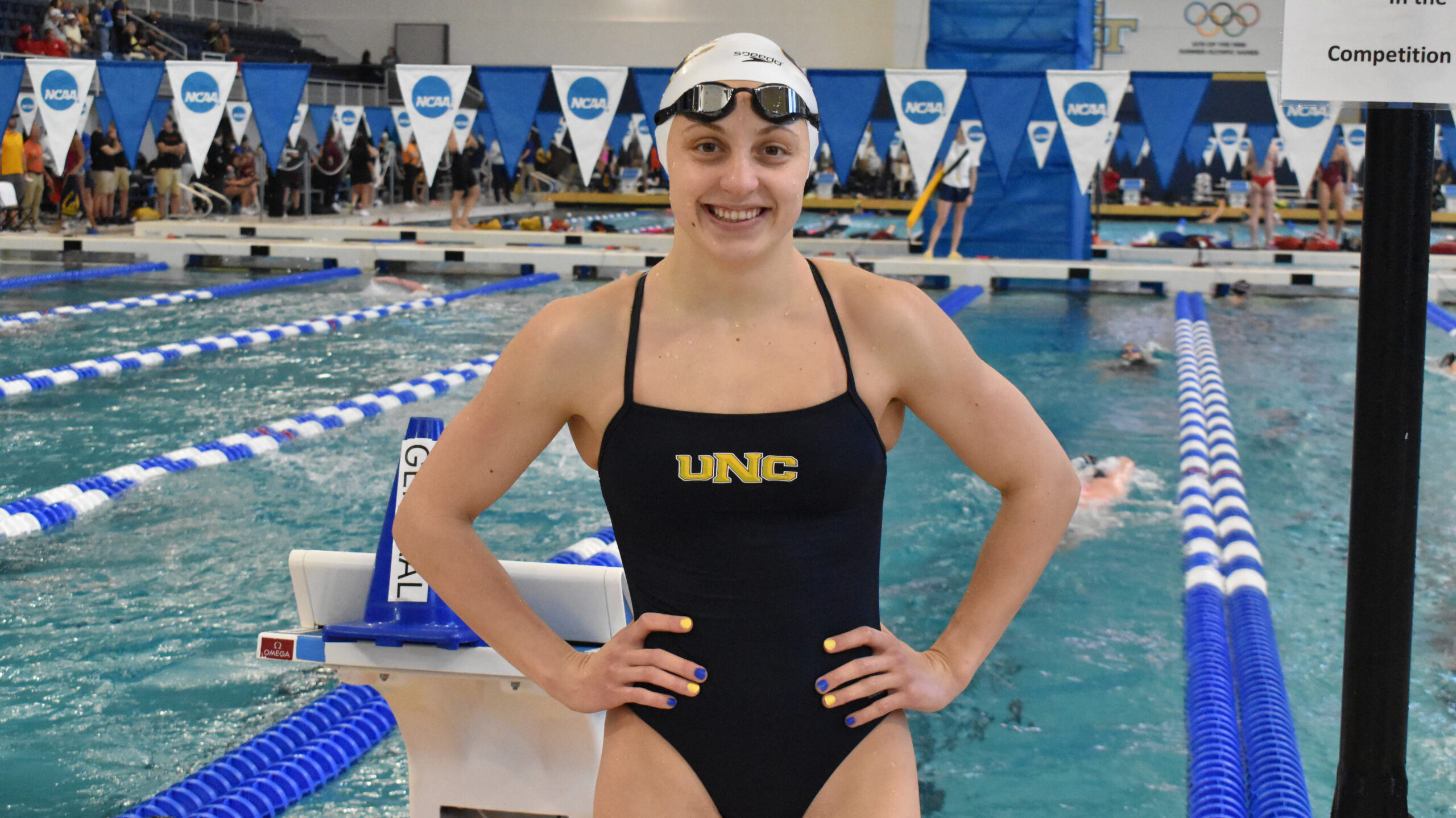 Maria Erokhina in a UNC swimsuit in front of a NCAA pool