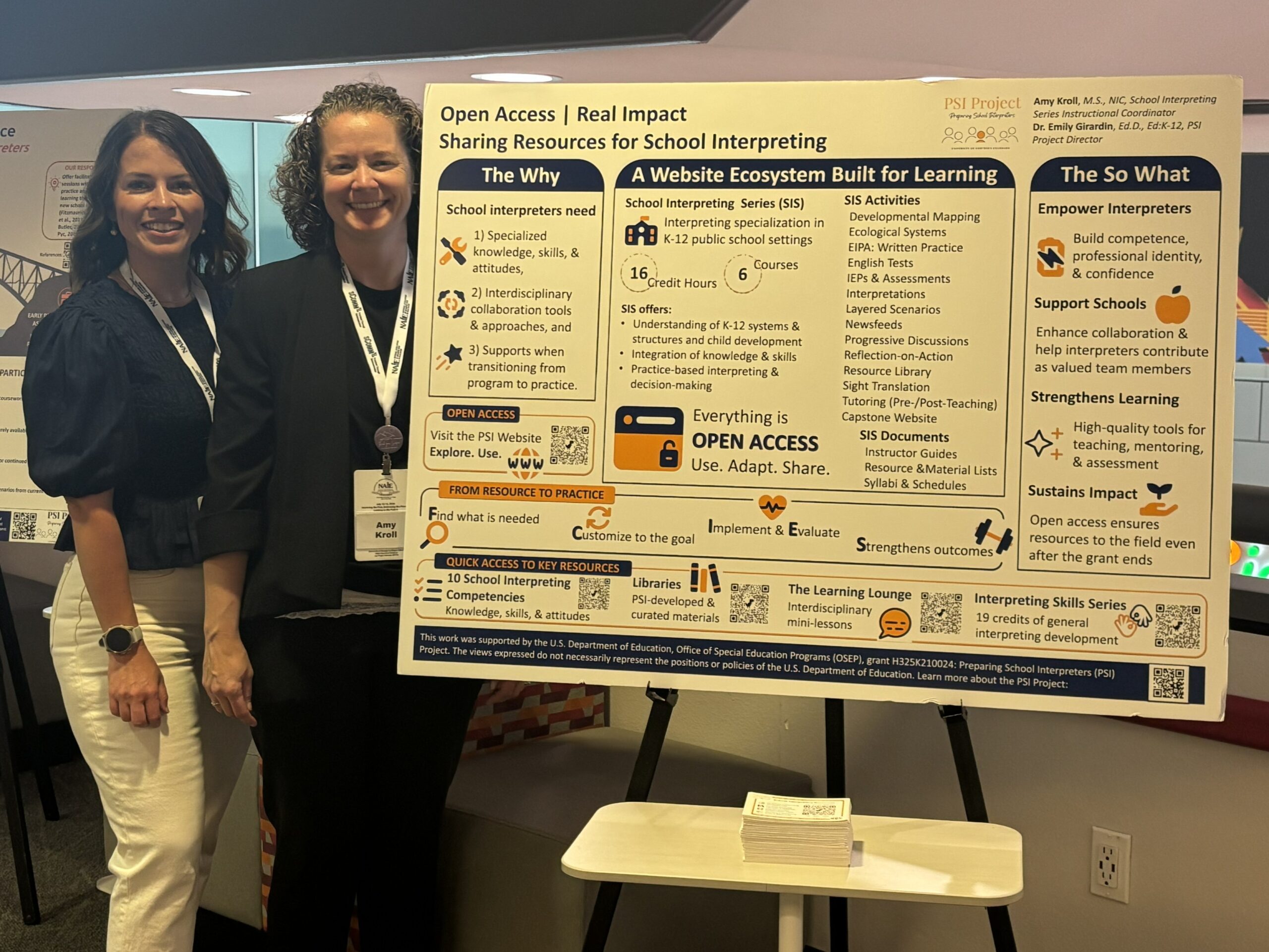 Amy Kroll and Dr. Emily Girardin standing beside their Open Access | Real Impact: Sharing Resources for School Interpreting poster at the 2026 NAIE Conference.