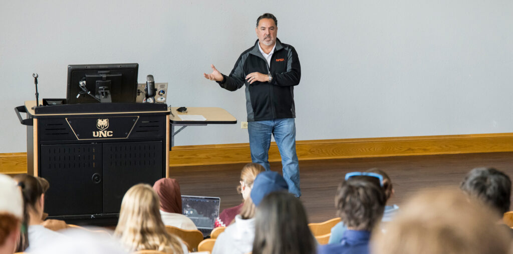 Walt Uglade talking to students who are sitting in chairs