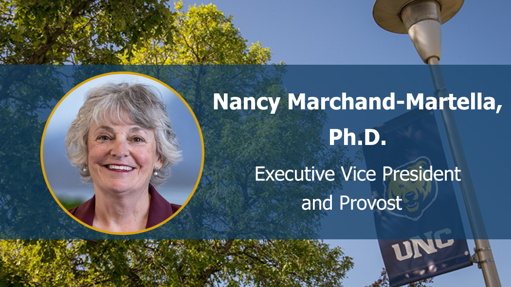 Photo of Nancy Mrchand-Martella facing front and smiling on UNC-branded background.