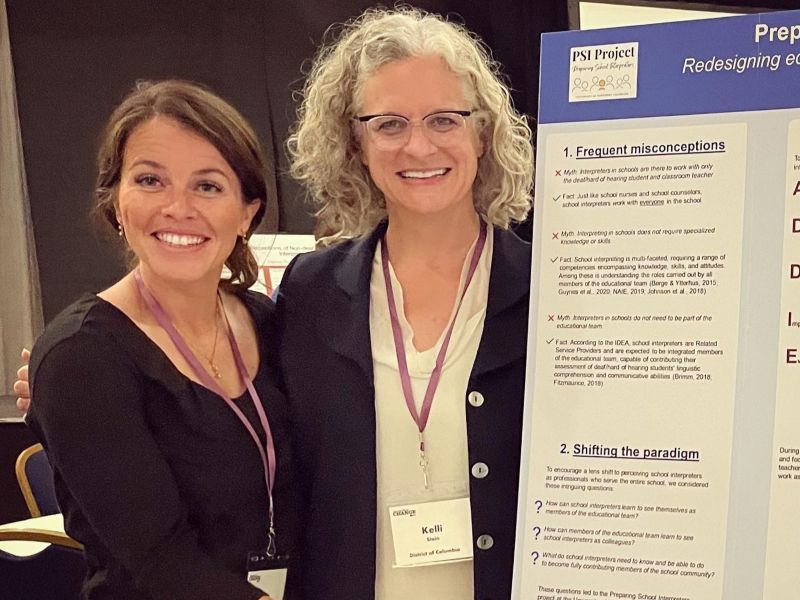 Dr. Emily Girardin and Kelli Stein stand beside their poster, “Preparing School Interpreters: Redesigning Educational Interpreting Curricula to Reflect an Interdisciplinary Lens,” at the Conference of Interpreter Trainers.