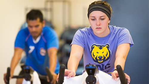Students in a group fitness class doing cycling.