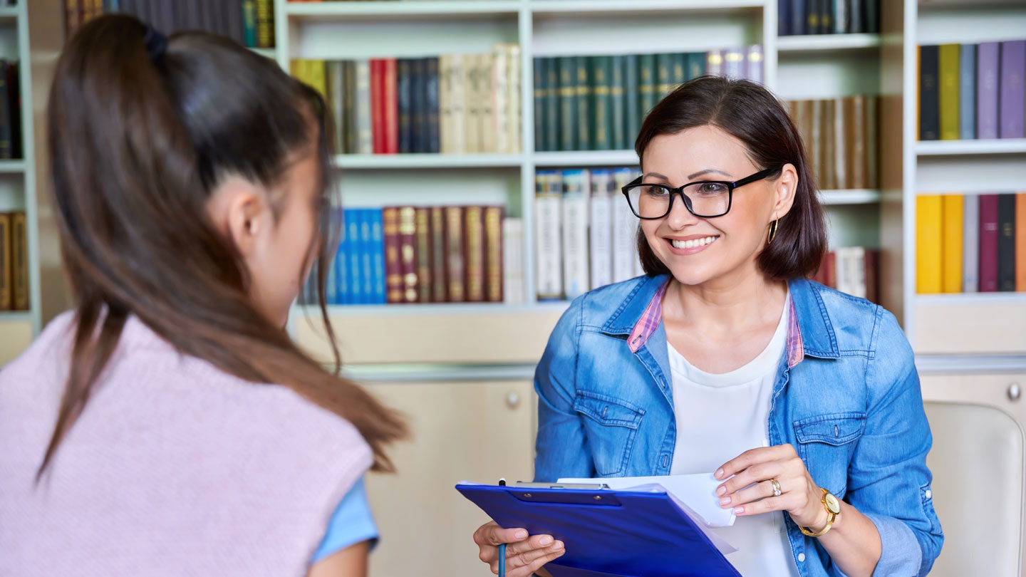 School psychologist talking to a student in a counseling session.