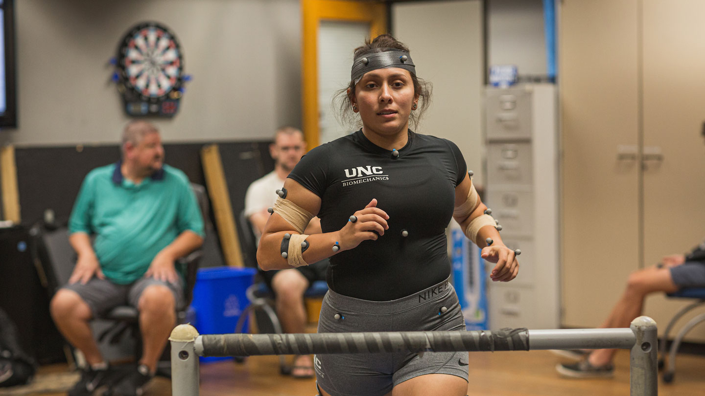 Athlete, with sensors attached, running on treadmill.