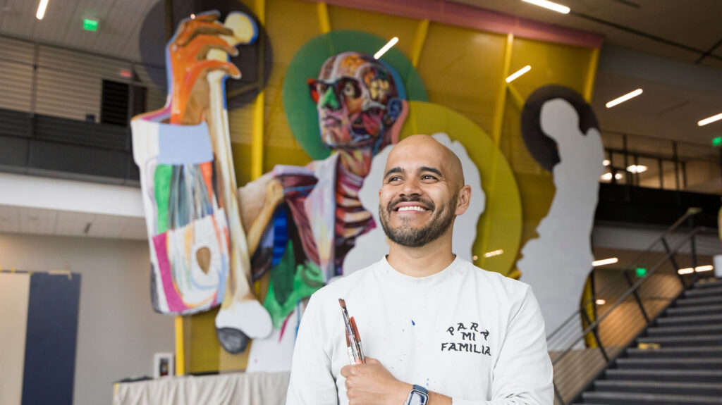 Armando Silva smiling in front of his mural