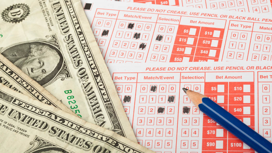 A close-up of several dollar bills and a paper betting card.