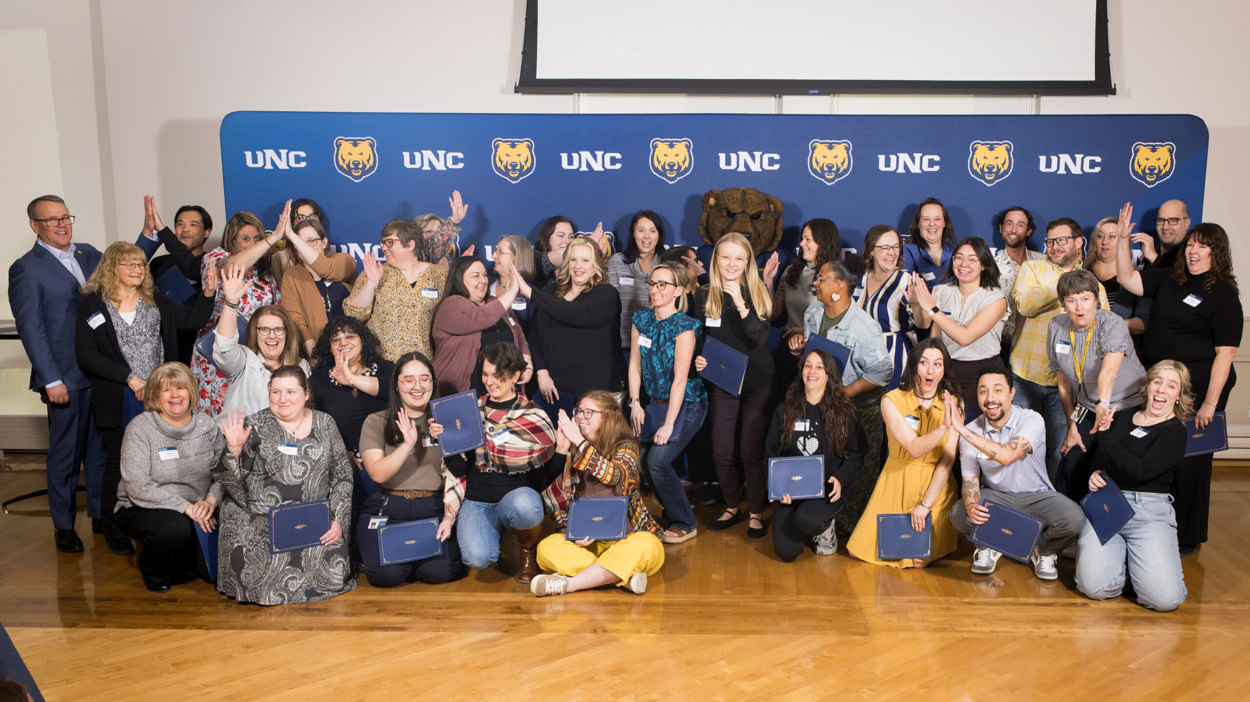 A group of UNC employees high-fiving each other