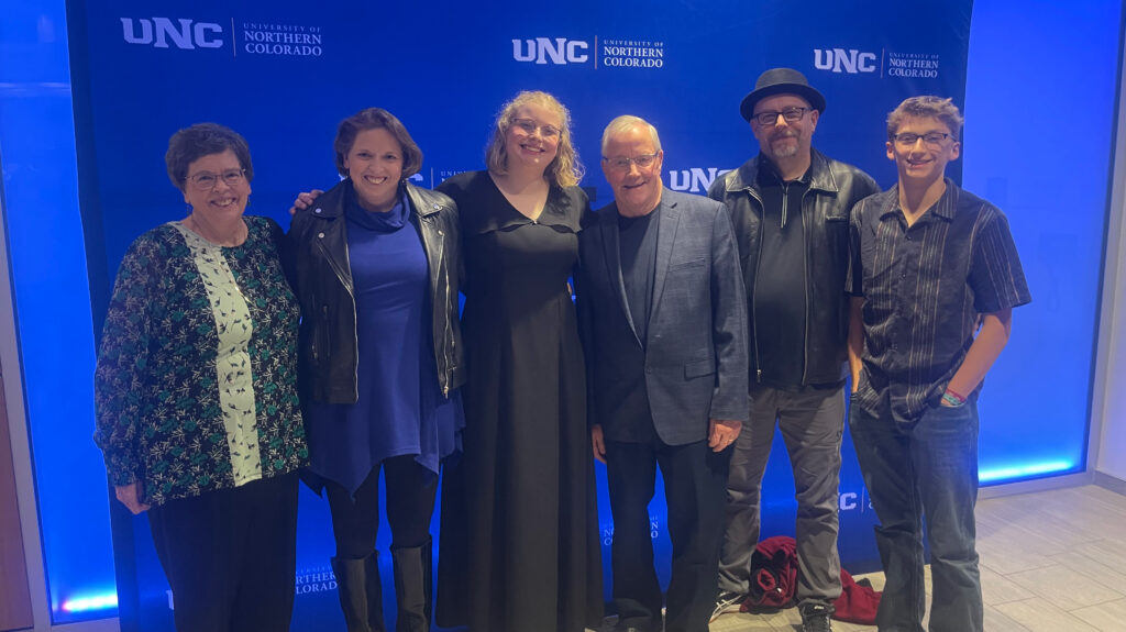 The White family standing in a row in front of a UNC backdrop