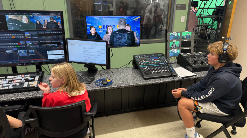 two middle school students sitting inside UNC's control room
