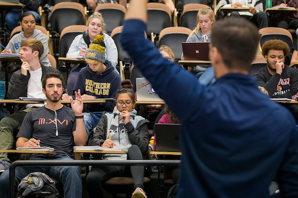 Student raising their hand to answer teacher's question