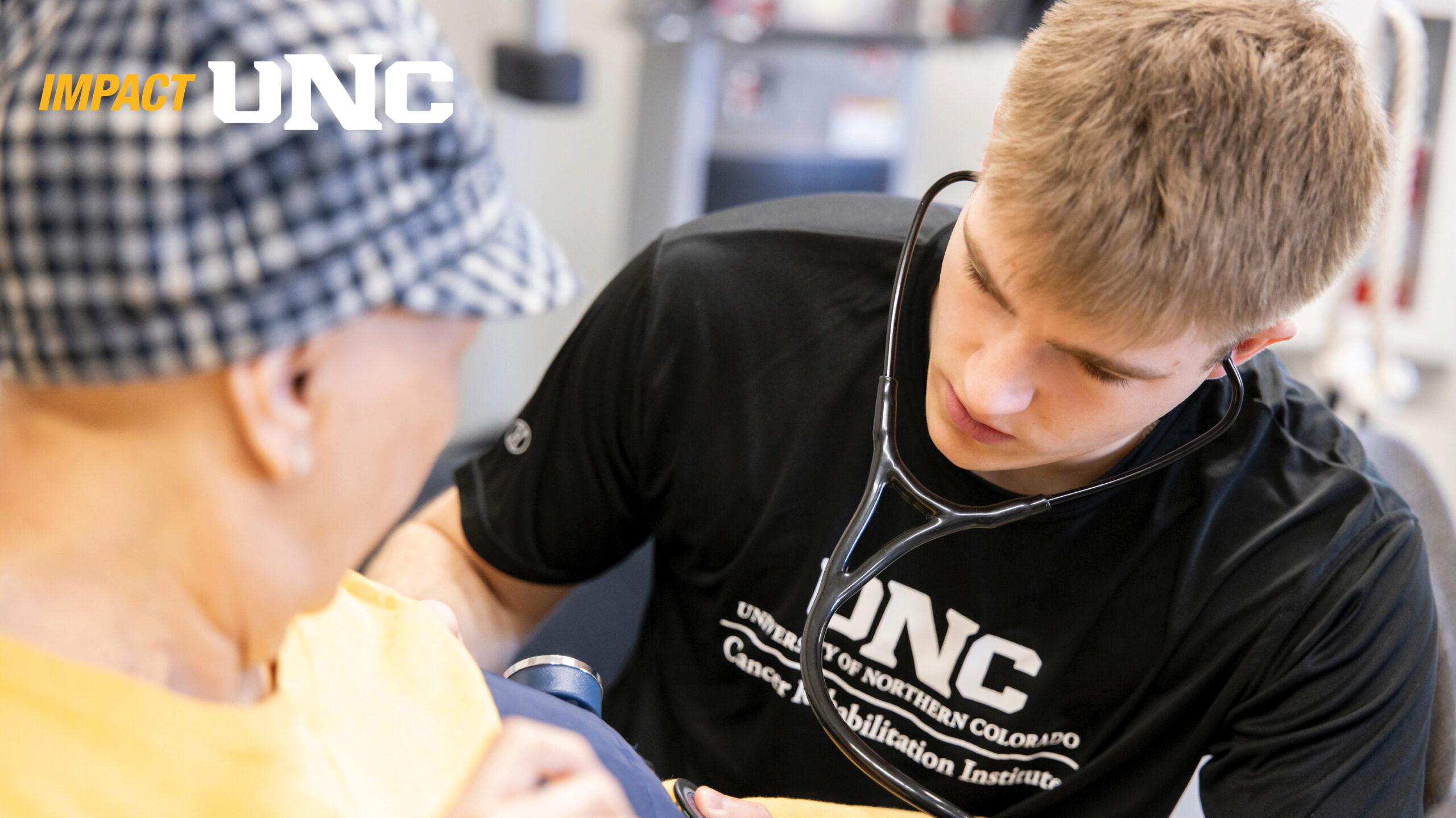 A student wearing a stethoscope with a patient