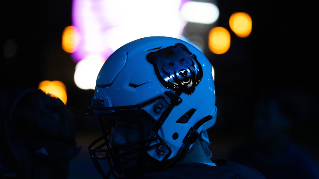 A UNC football helmet shining in the night light