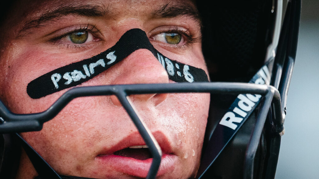 A close up of a football players face who has Psalms 118:6 on his face