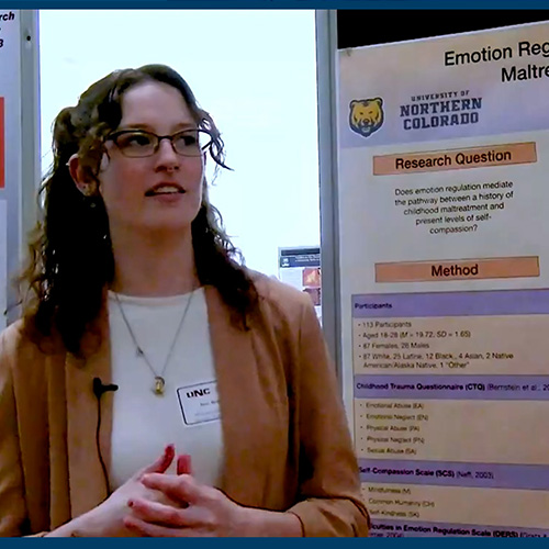 A student gives her research presentation at a research fair.