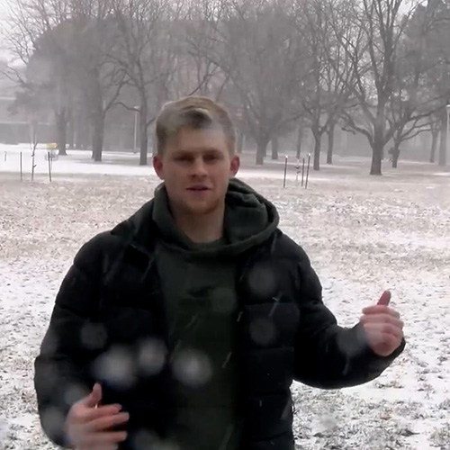 Reporter standing in the snow.