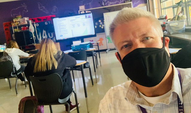Photo of Truman Solverud in his classroom, mask on